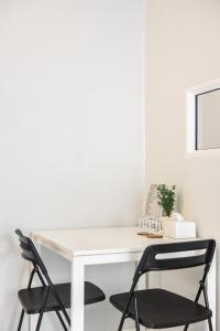 a white desk with two chairs in a room at PVILLA in Ban Phraek Sa