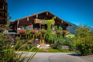 a wooden house with flowers on the front of it at Vordersattlegghofhütte in Hüttau