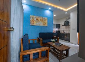 ein Wohnzimmer mit einem Tisch und einer blauen Wand in der Unterkunft Royal Tusker Luxury Service Apartments in Mysore