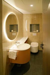 a bathroom with a tub and a toilet and a mirror at HABAKUK Wellness & Event Hotel in Maribor