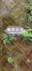 a sign on the side of a stone wall at Kumano Kodo Nagano Guesthouse in Tanabe
