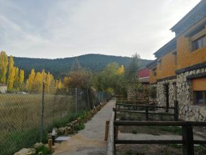 Vega del Cadorno的住宿－Casas Rurales La Trufa Madre Casa 2，围栏旁有长椅的建筑物