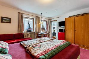 um quarto com uma cama e um sofá vermelho em Steinplatte em Reit im Winkl