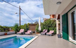 - une piscine avec des chaises roses à côté d'une maison dans l'établissement 3 Bedroom Lovely Home In Nova, à Vela Luka