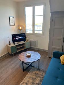 ブールジュにあるT2 4 pers face gare SNCF Appart Hotel le Cygne 5のコーヒーテーブルとテレビのあるリビングルーム