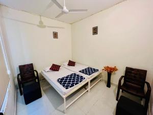 a bedroom with a bed and two chairs at Hostel ivory in Jaipur