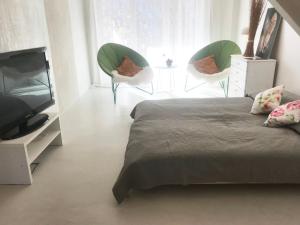 sypialnia z łóżkiem, 2 krzesłami i telewizorem w obiekcie Apartament Blanko w mieście Białystok