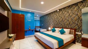 una camera con un grande letto e una parete blu di Royal Tusker Luxury Service Apartments a Mysore