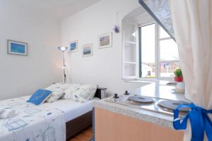 Dormitorio pequeño con cama y lavamanos en Apartman studio Stari Grad 2 en Stari Grad
