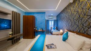 ein Schlafzimmer mit einem großen Bett und einer blauen Wand in der Unterkunft Royal Tusker Luxury Service Apartments in Mysore