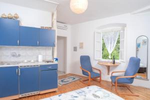 スタリー・グラードにあるApartman studio Stari Grad 2のキッチン(青いキャビネット、青い椅子、テーブル付)