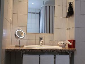 a bathroom with a sink and a mirror at Residenz Hotel am Zuckerberg in Trier