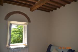 una finestra ad arco in una stanza con pareti bianche di La casa di Agata a Guardistallo