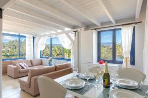 a living room with a table and chairs and a couch at Blue Haven Beach Loft Apartment in Danilia