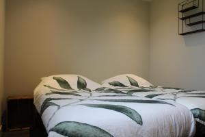 a bedroom with a bed with a green and white blanket at Grindweg 4C in Westkapelle