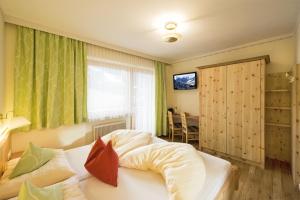 A bed or beds in a room at Ski in Ski out Hotel Unterellmau