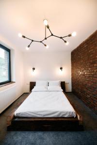 a bedroom with a bed with a brick wall at Liziera Blaj in Blaj