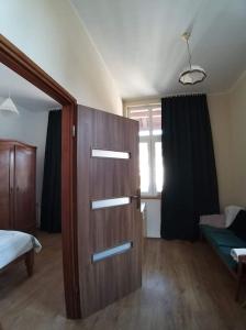 pokój z drzwiami, łóżkiem i oknem w obiekcie Nikifour, apartament nad deptakiem w mieście Krynica Zdrój
