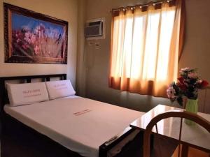 una camera con un letto, un tavolo e una finestra di WJV INN CASUNTINGAN a Mandaue