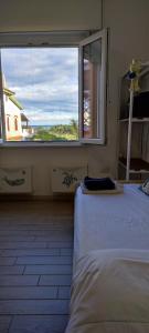 um quarto com uma cama e uma grande janela em Vistamare maddalena spiaggia em La Maddalena
