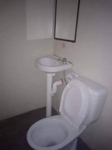 a bathroom with a white toilet and a sink at WJV INN CASUNTINGAN in Mandaue City