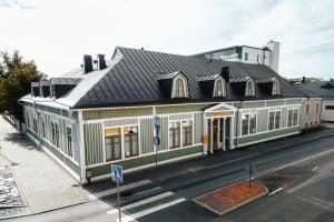 a large white building with a black roof on a street at Johanssonin talo 1849 in Joensuu