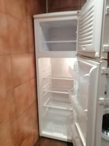 Un refrigerador vacío con la puerta abierta en una cocina. en Madrid, en Madrid