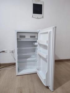 un réfrigérateur vide avec une porte ouverte dans une pièce dans l'établissement Rooms for rent 67, à Sassari