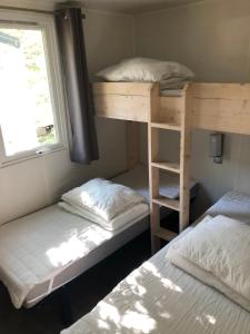 sypialnia z dwoma łóżkami piętrowymi i oknem w obiekcie Mobile home 5-pers Camping Leï Suves-Côtes d'Azur-including airco w mieście Roquebrune-sur Argens