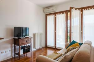 uma sala de estar com um sofá e uma televisão em QUIET PLACE close to city center em Desenzano del Garda