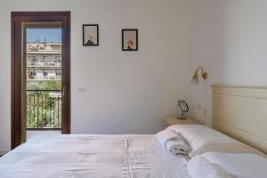 um quarto com uma cama branca e duas fotografias na parede em QUIET PLACE close to city center em Desenzano del Garda