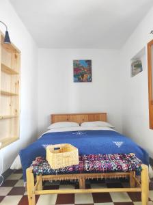 a bedroom with a bed with a basket on a bench at Vallparadis Pension Familiar" FIRDAUS" in Chefchaouen