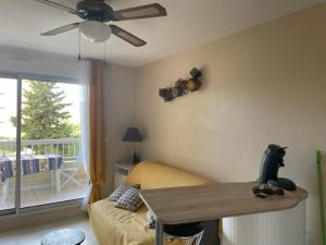 a bedroom with a bed and a table and a window at Appartement GRUISSAN Plage du Grazel in Gruissan