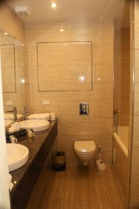 a bathroom with two sinks and a toilet and a tub at Seafront Hotel in Hirtshals