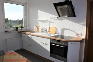 a kitchen with a sink and a stove and a window at Ferienwohnung Grünewaldstraße 22 in Bünde