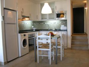 a kitchen with a table and a dishwasher at Almargem Villa 77 Cozy 1BR in Cabanas de Tavira, Near the Beach in Cabanas de Tavira +15 photos