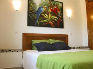 a bedroom with a bed with a painting on the wall at Almargem Villa 77 Cozy 1BR in Cabanas de Tavira, Near the Beach in Cabanas de Tavira