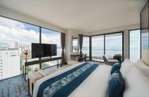 a bedroom with a large bed and a large window at Queen Ann Nha Trang Hotel in Nha Trang