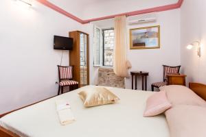 a room with a bed and two chairs and a window at Guesthouse Vicelic in Dubrovnik