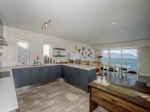 a kitchen with blue cabinets and a view of the ocean at Boulders Blue Bed and Breakfast in Simonʼs Town