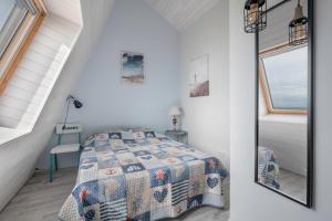 a bedroom with a bed and a window and a mirror at Face à la mer, appartement sous les toits pour 4 in Saint-Sébastien