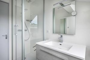 a white bathroom with a sink and a shower at Face à la mer, appartement sous les toits pour 4 in Saint-Sébastien +8 photos