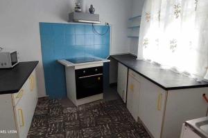 a small kitchen with a stove and blue tiles at La casa amarilla Candeleda in Candeleda