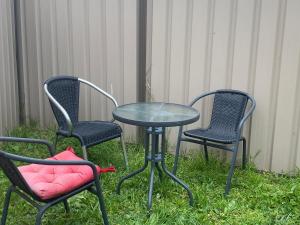 three chairs and a table with a table and two chairs at Townhouse in Mill Park