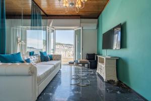a living room with a couch and a tv at Aura Celestia in Kavála