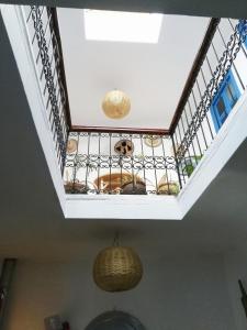 techo artesonado con balcón y lámpara de araña en Vallparadis Pension Familiar" FIRDAUS", en Chefchaouen