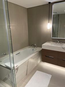 a bathroom with a tub and a sink and a mirror at Sharm 3 Bedroom Luxury Apartment in Sharm