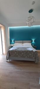 um quarto com uma cama grande e uma cabeceira azul em Suite Riviera 84 em Nápoles