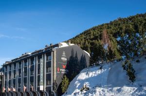 un edificio en la cima de una montaña cubierta de nieve en Hotel Austria by Pierre & Vacances, en Soldeu