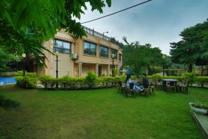 a man sitting at a table in front of a building at Hotel Shiv Villa in Mount Ābu